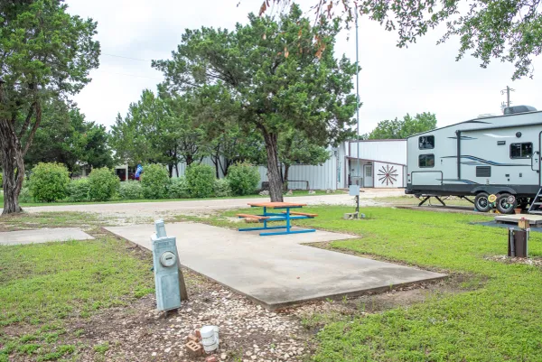 Open RV site with a concrete pad, picnic table and electric hookup